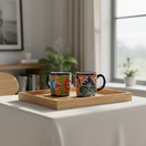The Talavera Hub hand-painted ceramic coffee mugs with vibrant floral patterns on a wooden tray.