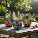 The Talavera Hub set of three hand-painted Mexican flower pots with colorful floral and geometric folk art designs.