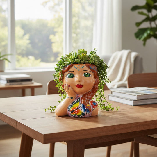 The Talavera Hub hand-painted ceramic lady planter with braided hair, green eyes, and butterfly motif. Mexican folk art.