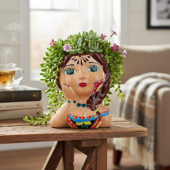 The Talavera Hub hand-painted ceramic lady planter with braided hair, green eyes, and colorful traditional attire.