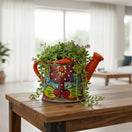 The Talavera Hub hand-painted ceramic watering can planter with floral design in orange, blue, yellow, and green.
