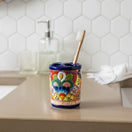 The Talavera Hub handcrafted ceramic toothbrush holder with vibrant hand-painted Mexican folk art and cobalt blue rim.