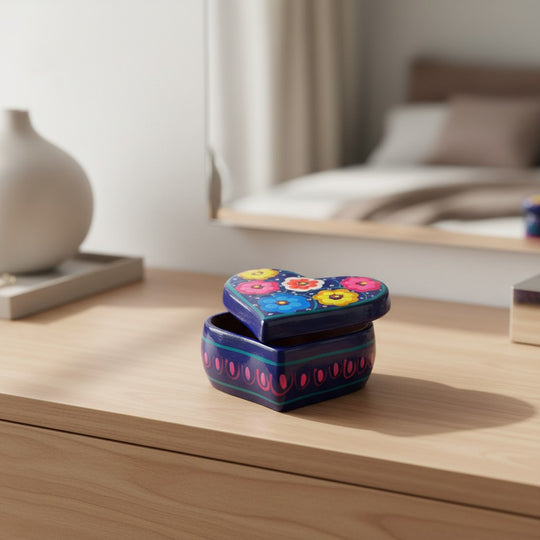 The Talavera Hub heart-shaped blue ceramic jewelry box with hand-painted floral lid on a wooden vanity