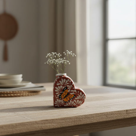 The Talavera Hub brown and white heart-shaped ceramic vase with a hand-painted butterfly design and delicate white flowers.