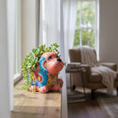 The Talavera Hub medium pink ceramic dog statue with vibrant hand-painted floral blue, green, and red Talavera designs.