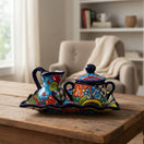 The Talavera Hub 3-piece Mexican ceramic coffee set with vibrant hand-painted floral patterns on a wooden table.