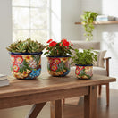 The Talavera Hub set of 3 hand-painted Mexican ceramic flower pots with vibrant floral and geometric folk art patterns.