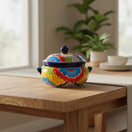 The Talavera Hub handmade ceramic soup pot with lid, featuring vibrant floral designs in blue, red, yellow, and green.