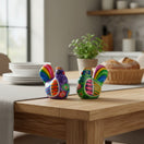 The Talavera Hub set of 2 hand-painted Mexican Guerrero pottery chicken salt and pepper shakers on a wooden table.