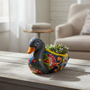 The Talavera Hub handmade Mexican ceramic duck planter with colorful floral folk art patterns and a succulent plant.