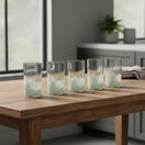 The Talavera Hub hand-blown Mexican highball glasses feature a clear top half and a white pebble-like pattern at the base. Set of 6.