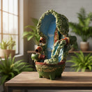 The Talavera Hub handcrafted Mexican outdoor fountain with a painted lady figure, blue water, and green accents. 24-inch tall.