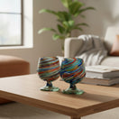 The Talavera Hub Hand-Blown Mexican Shot Glass with confetti swirl design in red, blue, green, and amber.