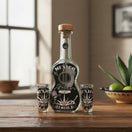 The Talavera Hub Mexican Tequila Decanter Set: guitar-shaped glass decanter with black and white Mexico design and two shot glasses.