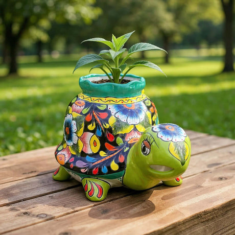 The Talavera Hub medium hand-painted ceramic turtle planter with vibrant floral designs and a green rim.