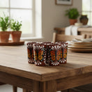 The Talavera Hub handcrafted shot glasses featuring vibrant orange and black monarch butterfly designs on brown ceramic.