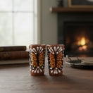 The Talavera Hub handcrafted ceramic shot glasses featuring vibrant orange and black monarch butterfly motifs.