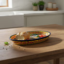 The Talavera Hub oval ceramic serving platter with a cobalt-blue rim and vibrant hand-painted Mexican patterns.