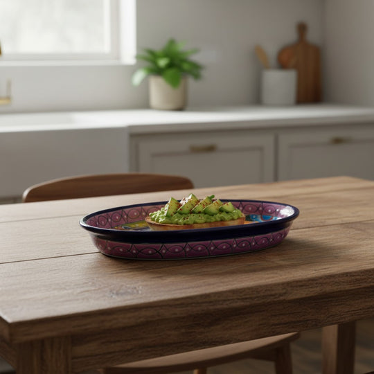 The Talavera Hub handmade oval ceramic serving platter with cobalt blue rim and vibrant hand-painted Mexican motifs.