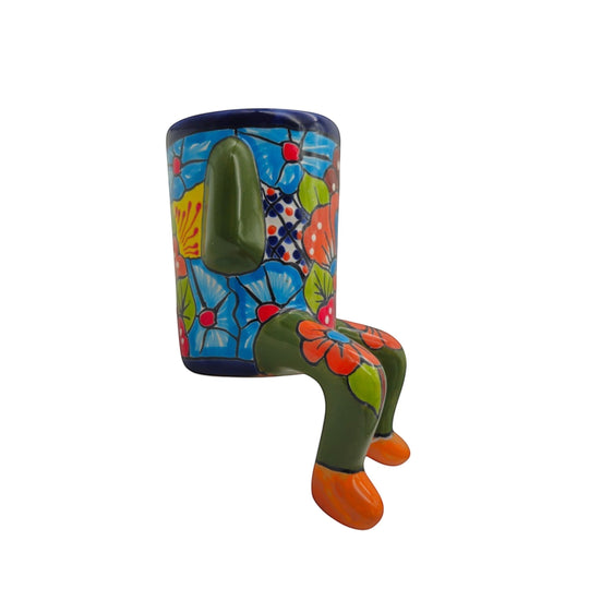 The Talavera Hub hand-painted ceramic planter with arms and legs, featuring a colorful floral design and green accents.