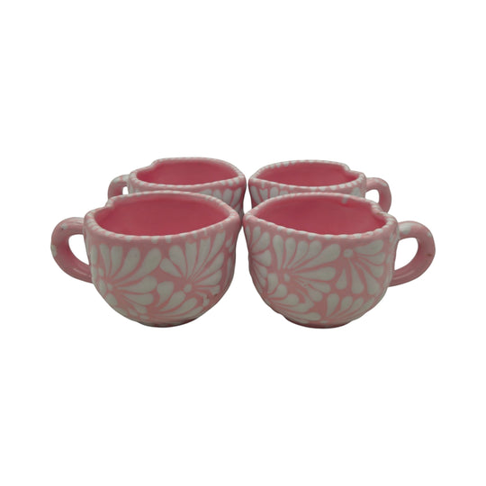The Talavera Hub set of four hand-painted pink ceramic heart-shaped mugs with white floral patterns.