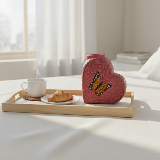 The Talavera Hub pink heart-shaped ceramic vase with a monarch butterfly design, featuring floral accents.