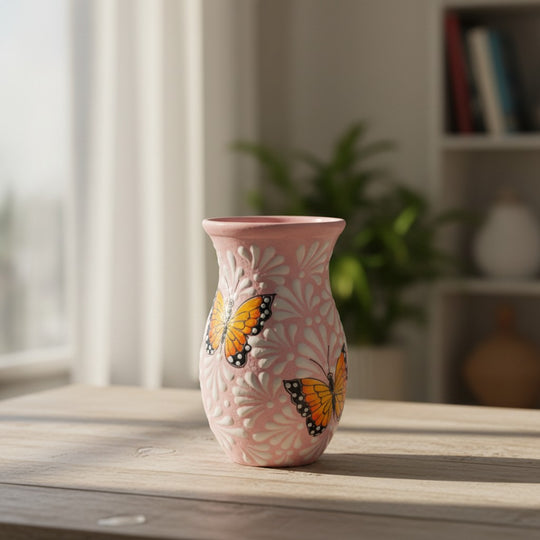 The Talavera Hub pink and white ceramic vase with monarch butterfly motif. Handcrafted in Mexico, featuring relief details.