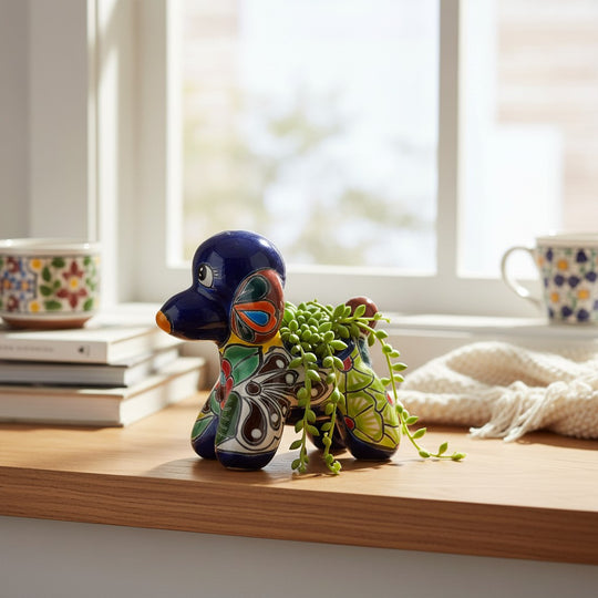 The Talavera Hub handcrafted ceramic poodle planter featuring vibrant blue, green, and orange Mexican folk-art patterns.