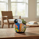 The Talavera Hub colorful hand-painted ceramic ram planter with floral designs and a succulent.