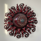 The Talavera Hub large red metal sun wall art with a face and light fixture. Handmade Mexican metalwork.