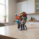 The Talavera Hub hand-painted ceramic Day of the Dead skull planter with floral motifs in red, green, blue, and yellow. 9.5" tall.