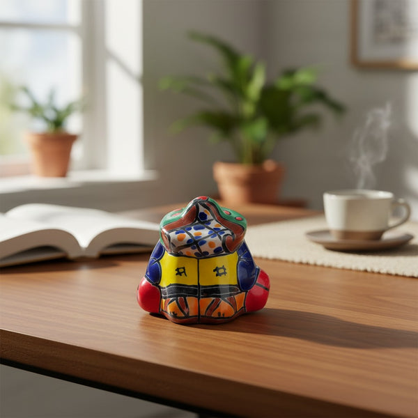 The Talavera Hub hand-painted ceramic Panchito figurine of a sleeping man, featuring vibrant blue, yellow, red, and green Talavera patterns.