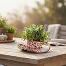 The Talavera Hub handcrafted brown and white floral sombrero planter filled with assorted succulents on a wooden table