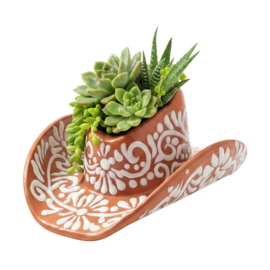 The Talavera Hub sombrero planter in brown and white with hand-painted floral patterns containing small succulents.