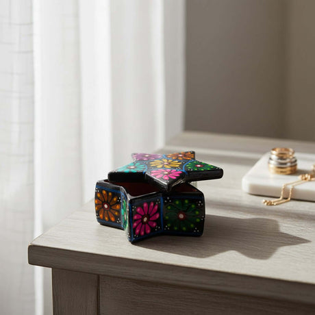 The Talavera Hub star-shaped ceramic jewelry box with vibrant hand-painted floral folk art motifs on a wooden table.