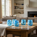 The Talavera Hub hand-blown stemless wine glasses with white and blue snow design, 12 oz capacity.