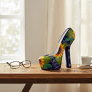 The Talavera Hub handcrafted ceramic high heel statue with blue background and vibrant yellow sunflower motif