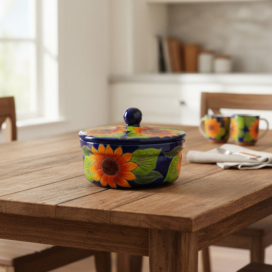 The Talavera Hub handmade ceramic tortilla warmer with sunflower motif on cobalt blue base. Features a knob lid.