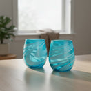 The Talavera Hub hand-blown stemless wine glass with teal and white swirl design. Recycled glass, 12 oz capacity.