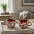 The Talavera Hub hand-painted terracotta mug with white floral design and dotted handle. Mexican coffee cup.
