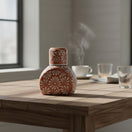 The Talavera Hub terracotta water carafe set with white hand-painted floral motifs on a wooden table.