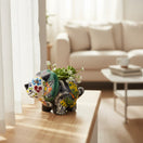The Talavera Hub Talavera Triceratops planter, a ceramic dinosaur with colorful floral patterns and butterflies, 6" long, 5" tall.