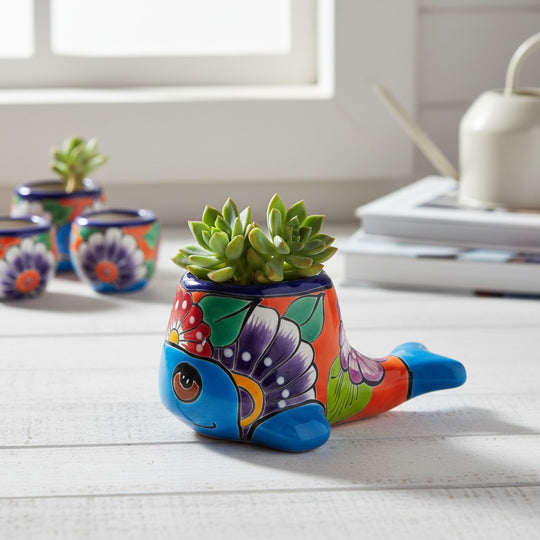 The Talavera Hub small whale-shaped ceramic planter with vibrant hand-painted floral patterns and a succulent plant.
