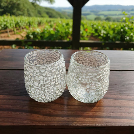 The Talavera Hub white pebbled stemless wine glasses, handmade in Mexico from lead-free glass with a frosted, cloud-like texture.