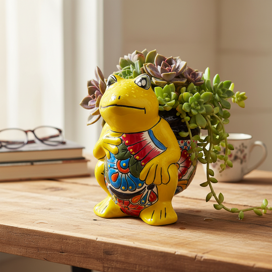 The Talavera Hub yellow ceramic frog planter with hand-painted colorful floral design on belly.