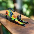 The Talavera Hub black ceramic cat statue with hand-painted sunflowers and green leaves, in a stretching pose.