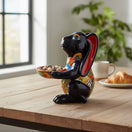 The Talavera Hub black ceramic bunny statue with red ears, holding a colorful patterned bowl. Handcrafted Mexican folk art.