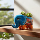 The Talavera Hub blue ceramic elephant planter with hand-painted floral details and orange feet.