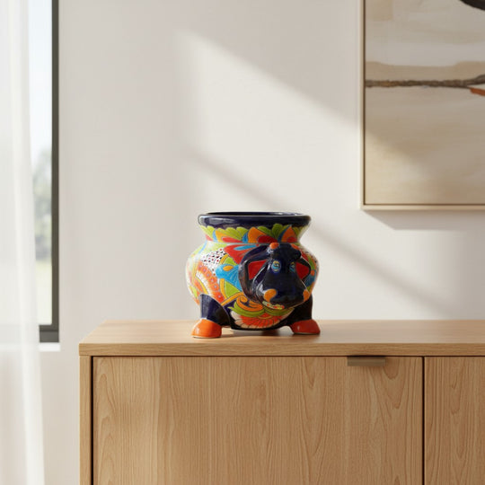 The Talavera Hub handcrafted blue cow planter, hand-painted with vibrant floral patterns and orange hooves.