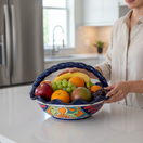 The Talavera Hub colorful hand-painted ceramic fruit basket with a braided blue rim and intricate floral designs.